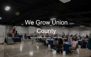 We Grow Union County in front of picture of people at a dinner